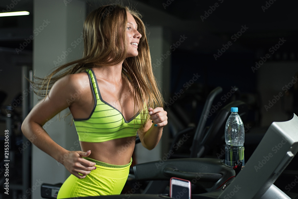Beautiful girl running on treadmill in gym, healthy lifestyle concept Beautiful girl running on treadmill in gym, healthy lifestyle concept