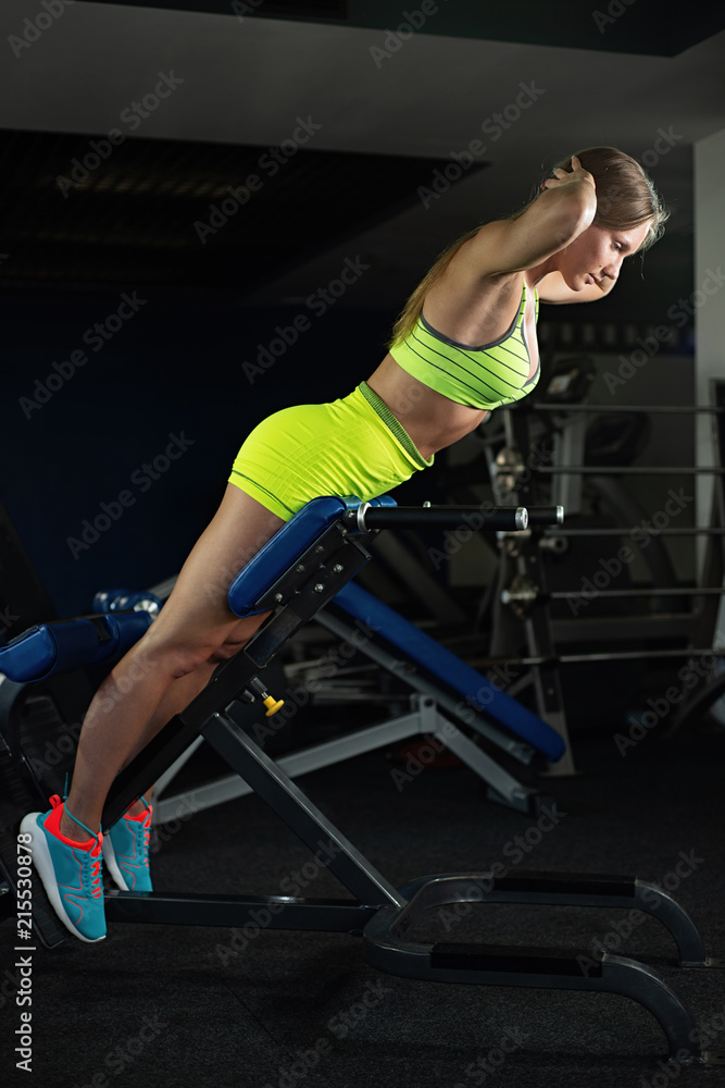 Sports young woman doing exercises on trainer back machine in the gym Sports young woman doing exercises on trainer back machine in the gym