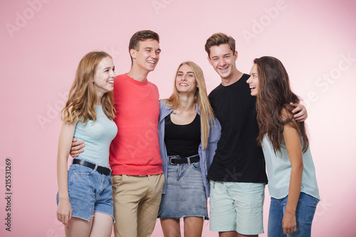 Happy smiling young group of friends standing together talking and laughing. Best friends