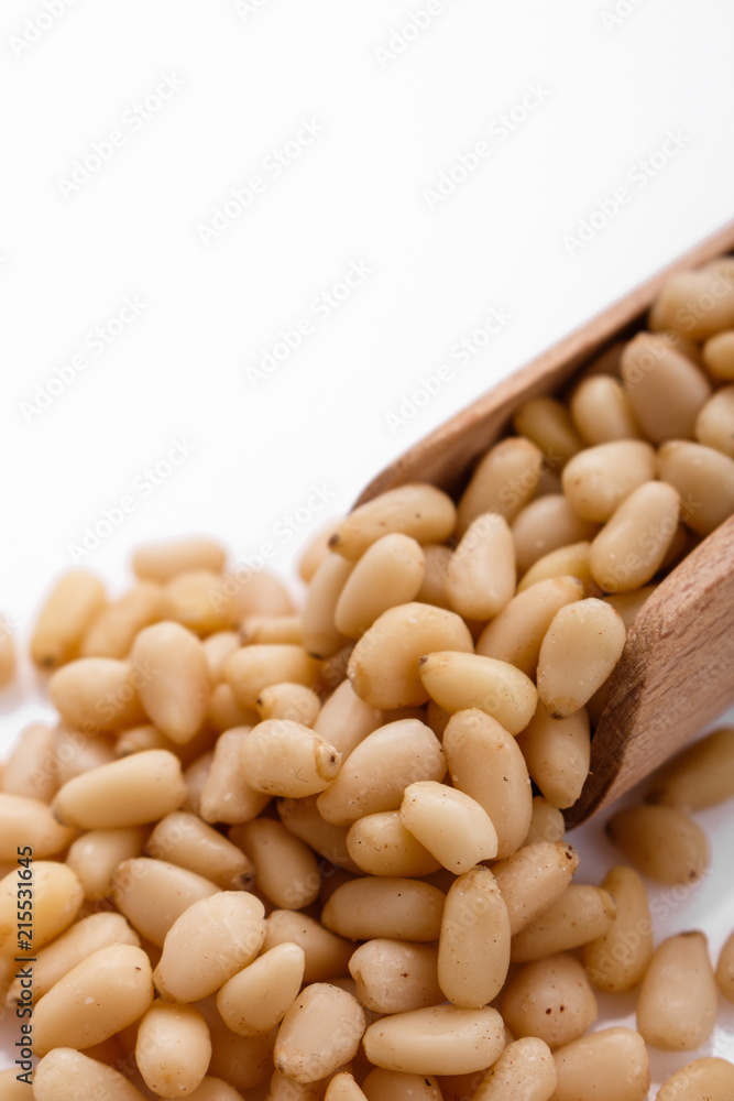 peeled pine nuts on a white acrylic background peeled pine nuts on a white acrylic background