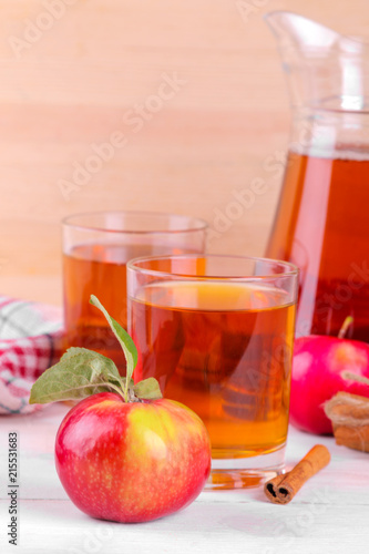 apple juice with fresh apples and cinnamon on a natural wooden background