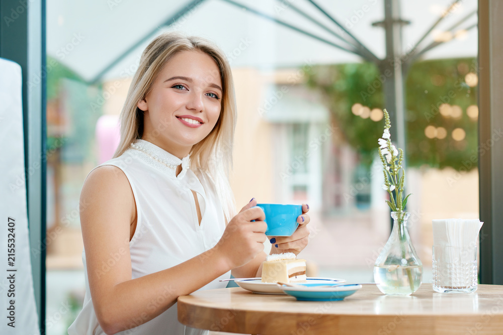 Cute blonde girl keeping cup of coffee on outdoors, smiling. Cute blonde girl keeping cup of coffee on outdoors, smiling.