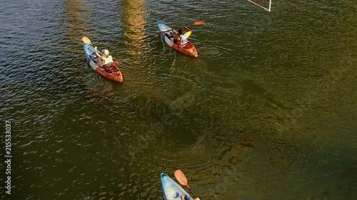 Group of people on kayaks rowing under a bridge in Austin Texas. photo