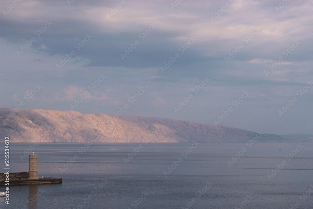 Lighthouse and bay in early morning light. In the background the island Krk. Senj, Croatia, South Europe.