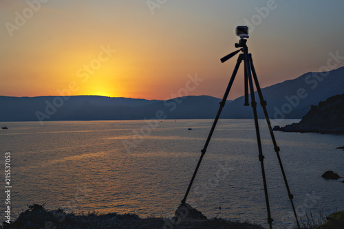 The process of photography. Tripod on the background of the setting sunset