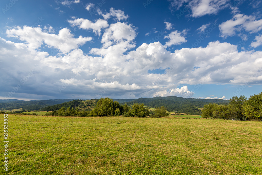 Rural scenery. Fields, mountains and clouds on the sky. Pieniny National Park. Malopolska, Poland.