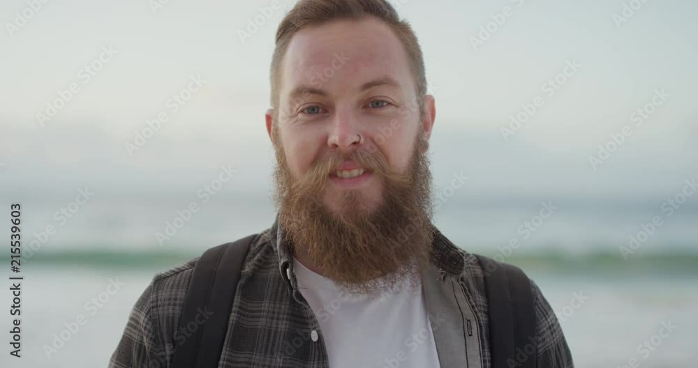 portrait of young bearded man smiling looking at camera on beach enjoying positive lifestyle handsome hipster male at seaside portrait of young bearded man smiling looking at camera on beach enjoying positive lifestyle handsome hipster male at seaside