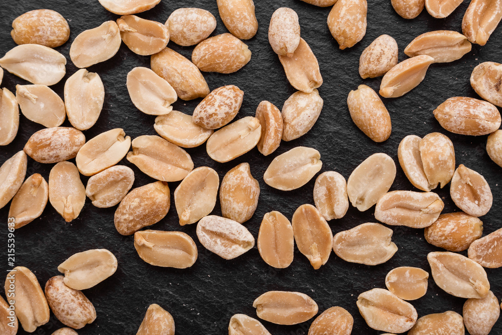 Obraz premium fresh peanuts on a dark stone background