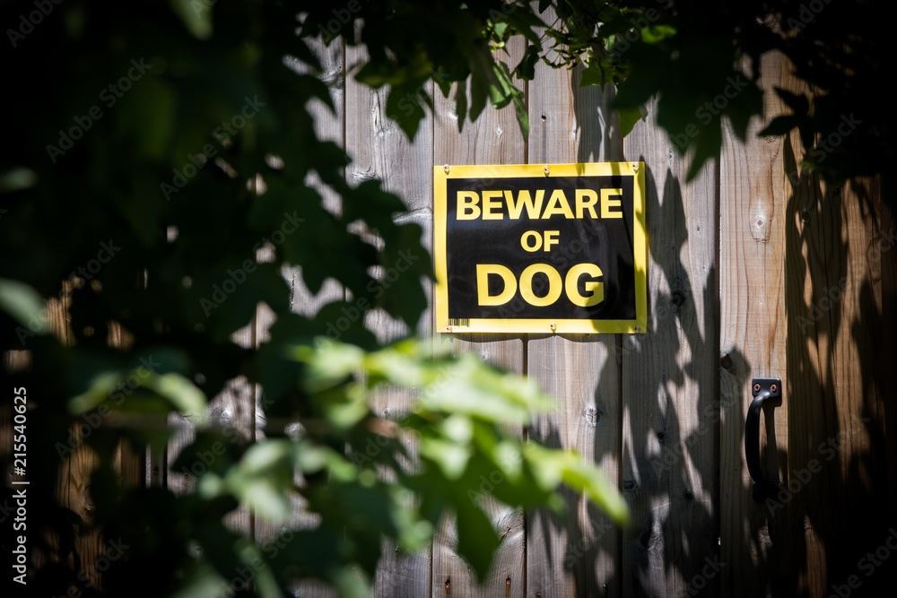 beware of dog warning sign on wooden fence