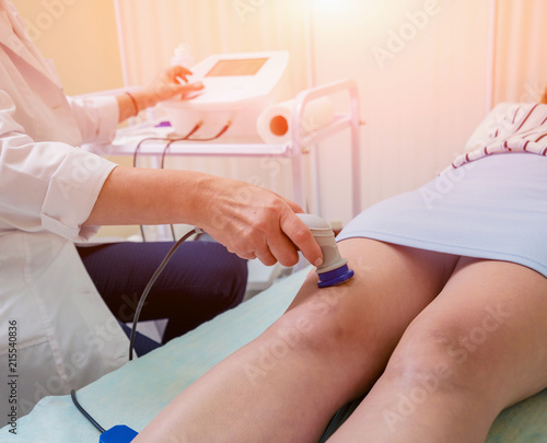 Doctor using machine to treat the knee joints of a patient. T-CaRe technology.