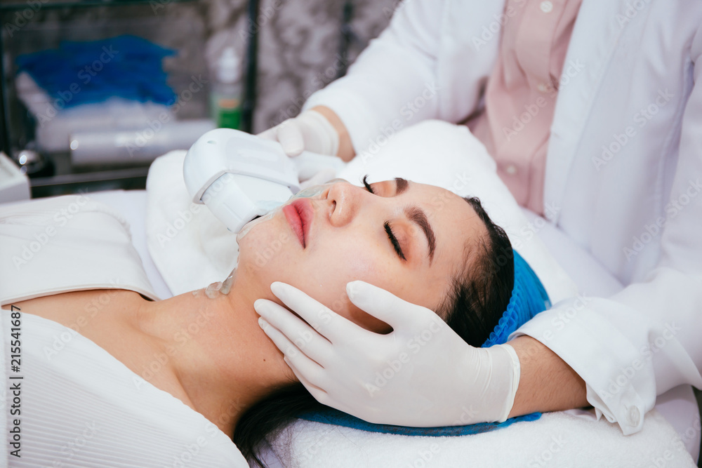 Young Asian woman getting IPL and laser treatment by beautician at beauty clinic.