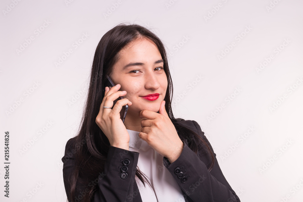 Beautiful asian girl in formal clothes with phone on white background Beautiful asian girl in formal clothes with phone on white background