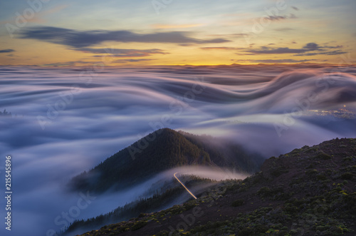 beautiful spectacle of flowing clouds over the ocean and mountains at sunrise, slow shutter speed.Tenerife,Spain