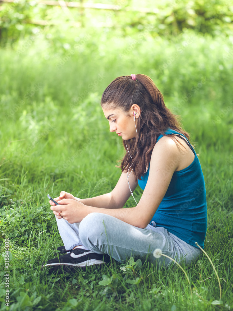 Beautiful girl resting in forest speak by cell phone, sports girl Beautiful girl resting in forest speak by cell phone, sports girl