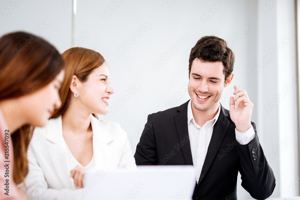 Obraz premium businessman talking and smiling.Young team of coworkers making great business discussion in modern office.Teamwork people concept.