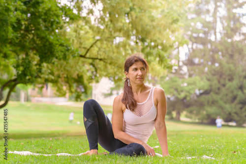 Fit woman sitting in a park on the grass