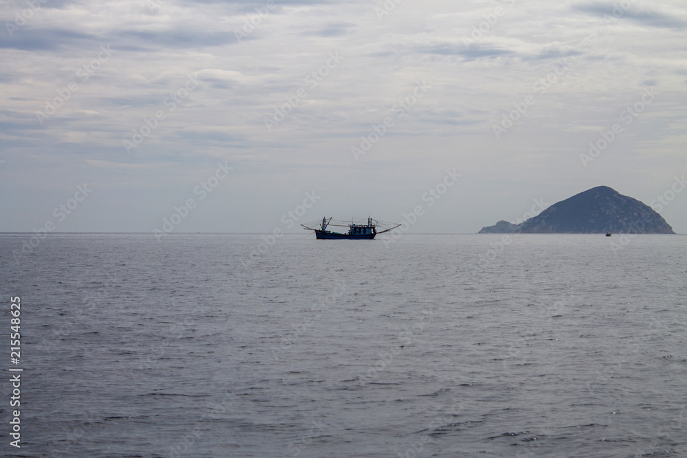 одинокая рыбацкая лодка в туманном море