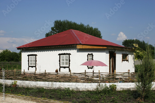 Rural house in white with a red iron roof. © AKlion