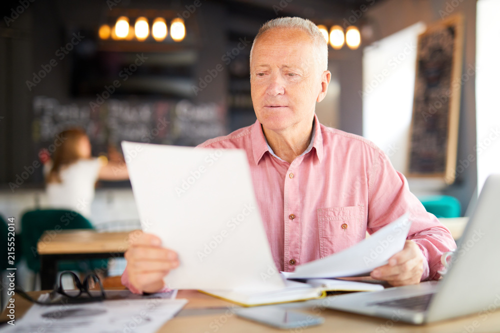 Businessman reading papers and preparing contract for client before meeting Businessman reading papers and preparing contract for client before meeting