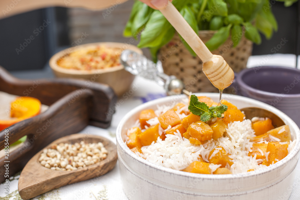 Sweet rice with pumpkin and spices and honey. Autumn lunch for the whole family in the courtyard. Copy space, Sweet rice with pumpkin and spices and honey. Autumn lunch for the whole family in the courtyard. Copy space,