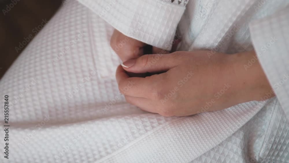 The girl's hands on a white robe. The girl's hands on a white robe.