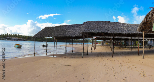 Tent of straw on the beach and boats on the bank of the river in Barra da Siribinha, Sítio do Conde, Bahia, Brazil