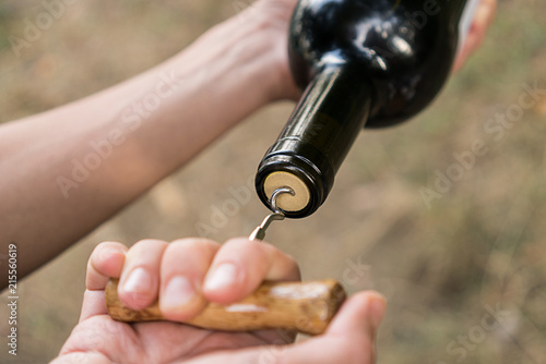 Man opens a bottle of wine corkscrew old
