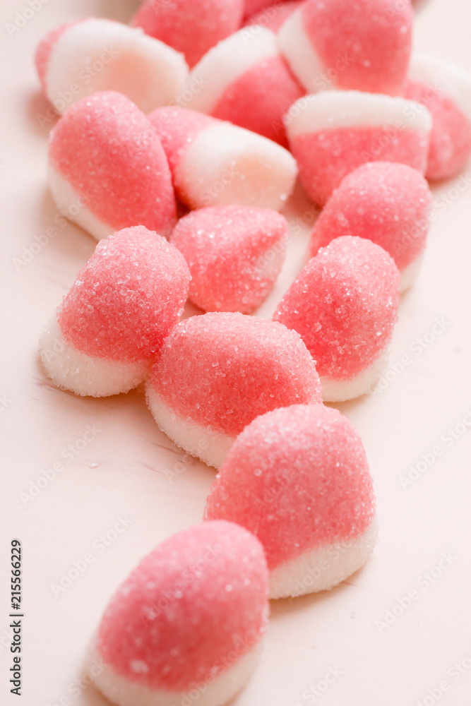 Pink jellies or marshmallows with sugar on table Pink jellies or marshmallows with sugar on table