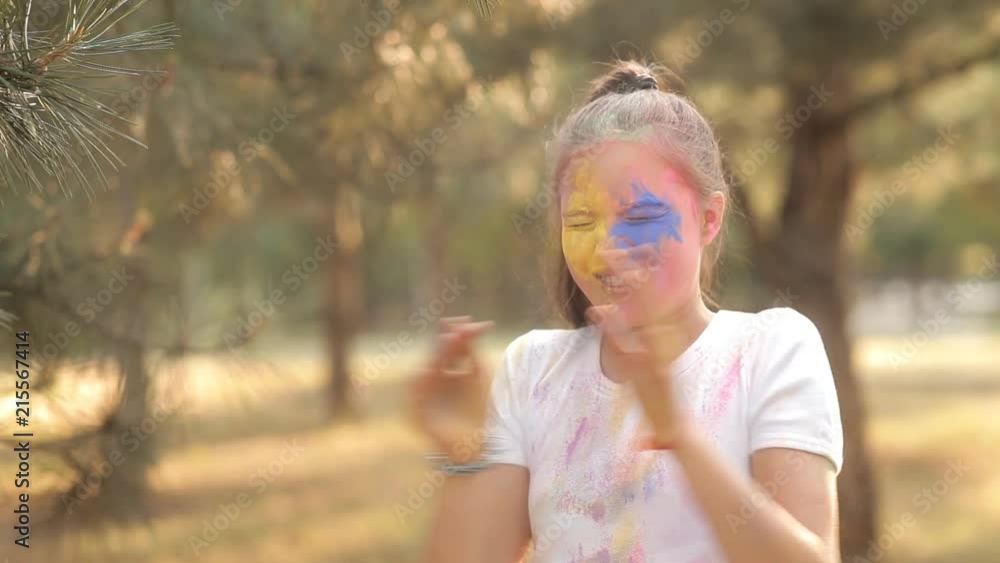 A child has fun playing in nature playing with colorful paints and sand. He pours colored sand on his face. Children's joy. Children's games A child has fun playing in nature playing with colorful paints and sand. He pours colored sand on his face. Children's joy. Children's games