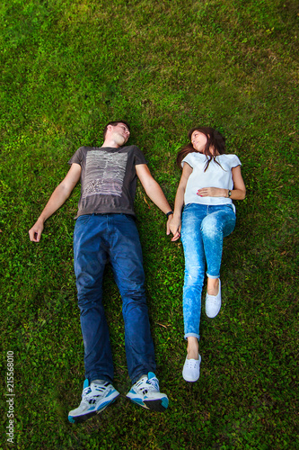 Loving couple on the grass lying. on a sunny summer day