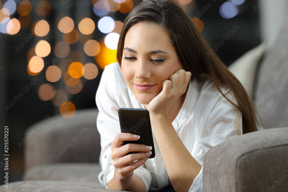 Girl reading phone messages at home in the night Girl reading phone messages at home in the night