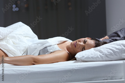 Woman having a nightmare in the bed in the night photo