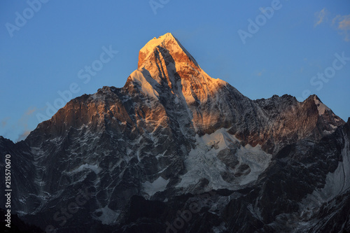 Four Girls Mountain National Park near Xiaojin, Sichuan Province China. Summit of the mountain during sunset, golden peak Jinshan. Mount Siguniang, Highest mountain of the Qionglai range.