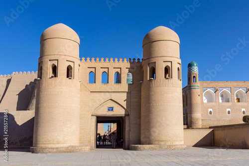 Twin-turreted West Gate with Madrassah of Muhammad Amin-khan in background - Khiva, Uzbekistan photo