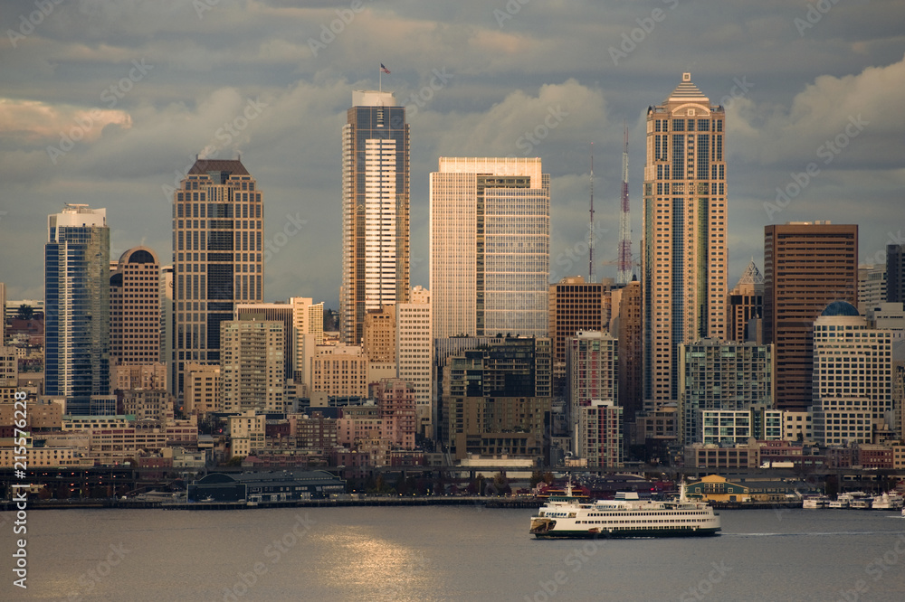 Fototapeta premium Seattle Skyline After A Rain Squall. Dramatic clouds surround the city of Seattle and the vibrant waterfront with modern skyscrapers looming large in the background.