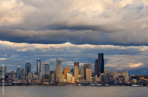 Seattle Skyline After A Rain Squall. Dramatic clouds surround the city of Seattle and the vibrant waterfront with modern skyscrapers looming large in the background. photo