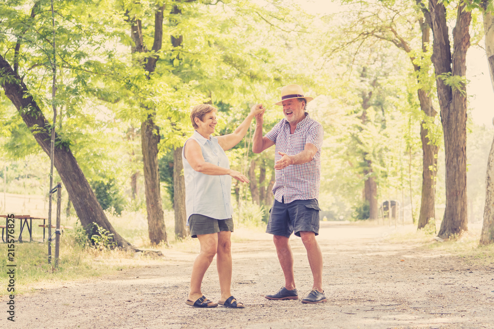Happy smiling senior couple in love, dancing and having fun in the park. Being together, in love, retirement happy life concept. Happy smiling senior couple in love, dancing and having fun in the park. Being together, in love, retirement happy life concept.