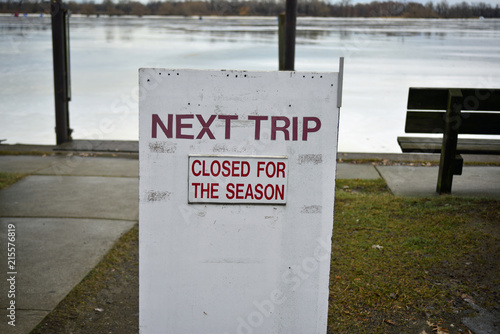 Water taxi station closed for the season, rectangular sign with red letters photo