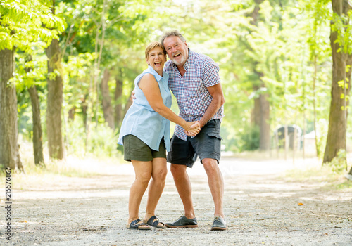Fototapeta Naklejka Na Ścianę i Meble -  Happy smiling senior couple in love, dancing and having fun in the park. Being together, in love, retirement happy life concept.