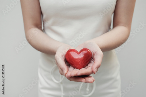 Young woman holding red heart, health insurance, donation concept