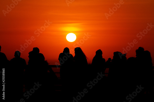 Silhouettes of people at sunset in front of the Pacific Ocean in the neighborhood of Miraflores (Lima, Peru)