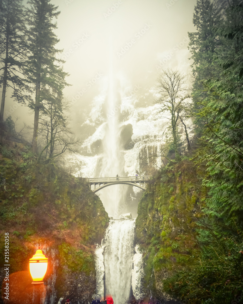 Fototapeta premium Vintage tone crowded of visitor at the main lookout of the base of Multnomah Falls in winter time. A waterfall on the Oregon side of the Columbia River Gorge, along the Historic Columbia River Highway