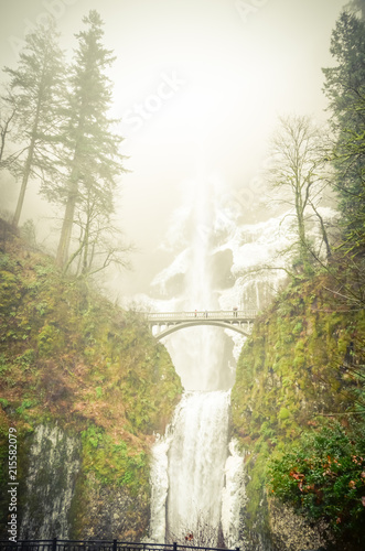 Vintage tone icy Multnomah Falls in winter time. It is a waterfall on the Oregon side of the Columbia River Gorge, along the Historic Columbia River Highway. Natural and seasonal waterfall background photo