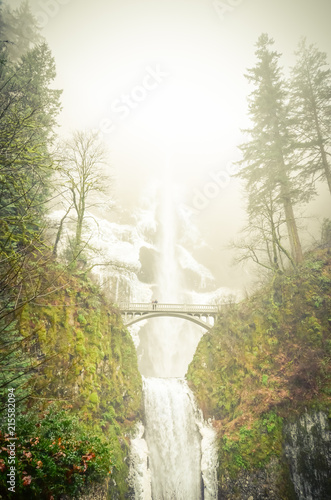 Vintage tone icy Multnomah Falls in winter time. It is a waterfall on the Oregon side of the Columbia River Gorge, along the Historic Columbia River Highway. Natural and seasonal waterfall background photo