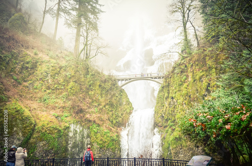 Vintage tone crowded of visitor at the main lookout of the base of Multnomah Falls in winter time. A waterfall on the Oregon side of the Columbia River Gorge, along the Historic Columbia River Highway photo