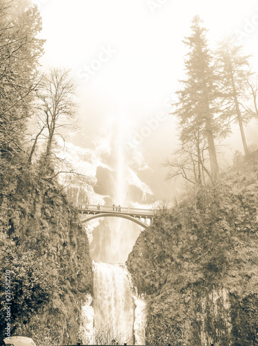 Vintage tone icy Multnomah Falls in winter time. It is a waterfall on the Oregon side of the Columbia River Gorge, along the Historic Columbia River Highway. Natural and seasonal waterfall background photo