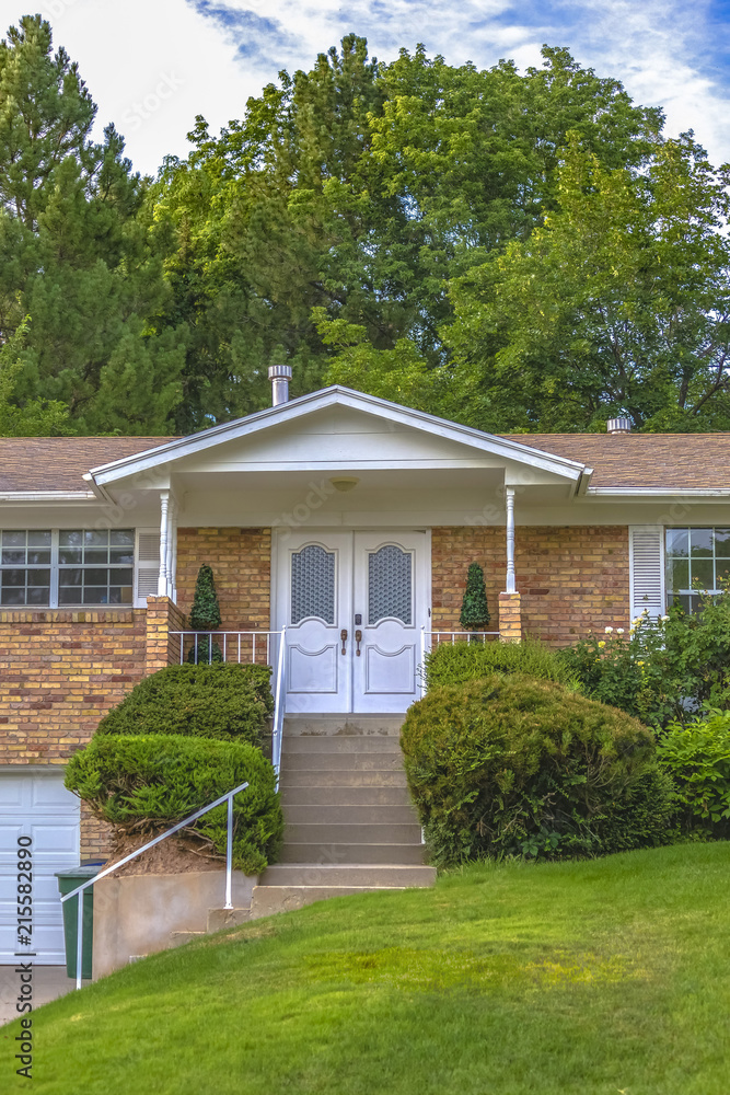 Lawn and shrubs leading to a white front door Lawn and shrubs leading to a white front door