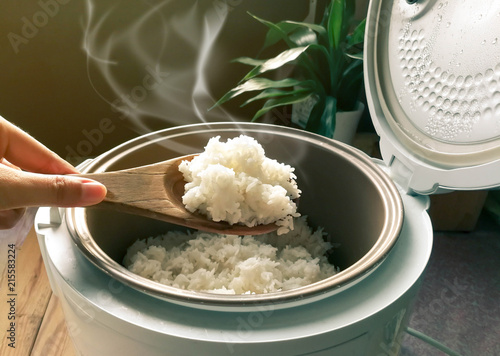 Jasmine rice cooking in electric rice cooker with steam. Soft Focus, Rustic tone picture.