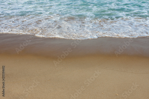Fototapeta Naklejka Na Ścianę i Meble -  Background of foamy waves rolling up the beach with beautiful turquoise water - room for text