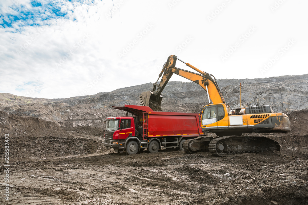 Large quarry dump truck. Loading the rock in dumper. Loading coal into body truck. Production useful minerals. Mining truck mining machinery, to transport coal from open-pit as the coal production. Large quarry dump truck. Loading the rock in dumper. Loading coal into body truck. Production useful minerals. Mining truck mining machinery, to transport coal from open-pit as the coal production.